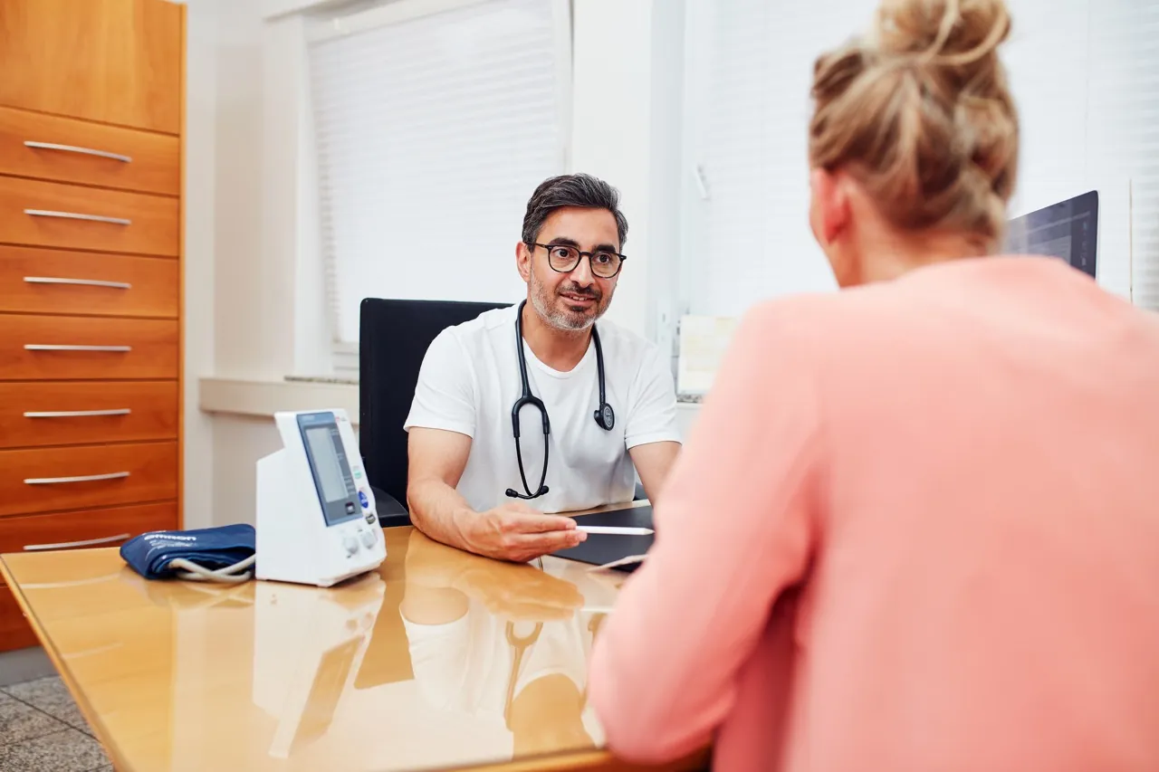 Sami Gaber in consultation with a patient at his desk at Hausarztpraxis Gaber